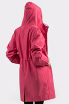 A person models the Icon Windbreaker Rain Jacket in bright pink, facing away from the camera with hands on hips against a plain white background.