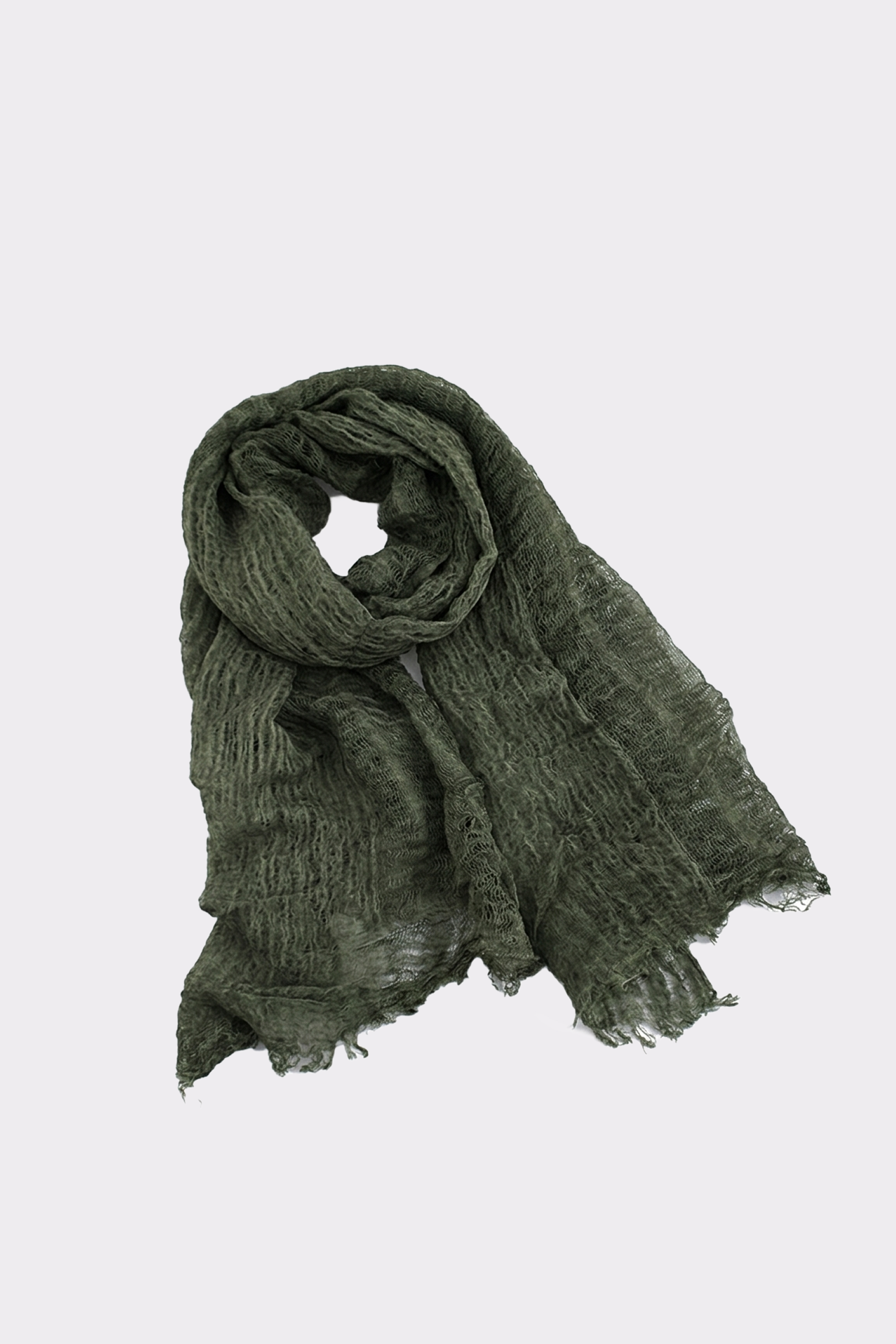 The Lightweight Linen Scarf, in dark green linen, lies flat on a light grey background with one end rolled and slightly frayed edges—an ultra-breathable, versatile accessory for any season.