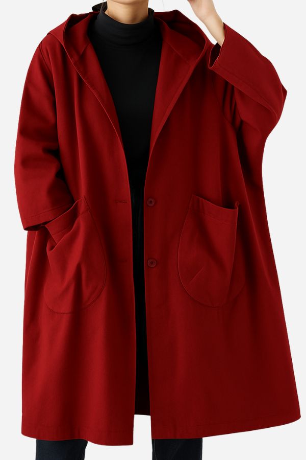A person wears the looselyboho Burgundy One Size Fits All Oversized Water Resistant Windbreaker Jacket, knee-length with a hood and large front pockets, over a black turtleneck. The middle is buttoned, and their face is not visible.