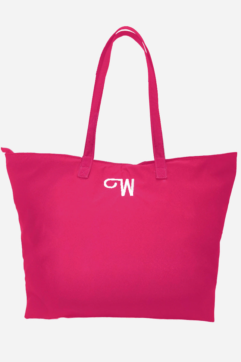 The Free Gift Urban Slate Waterproof bag is a large, bright pink duffel with smart organization, two handles, and a white embroidered "M" near the top center, shown against a plain white background.